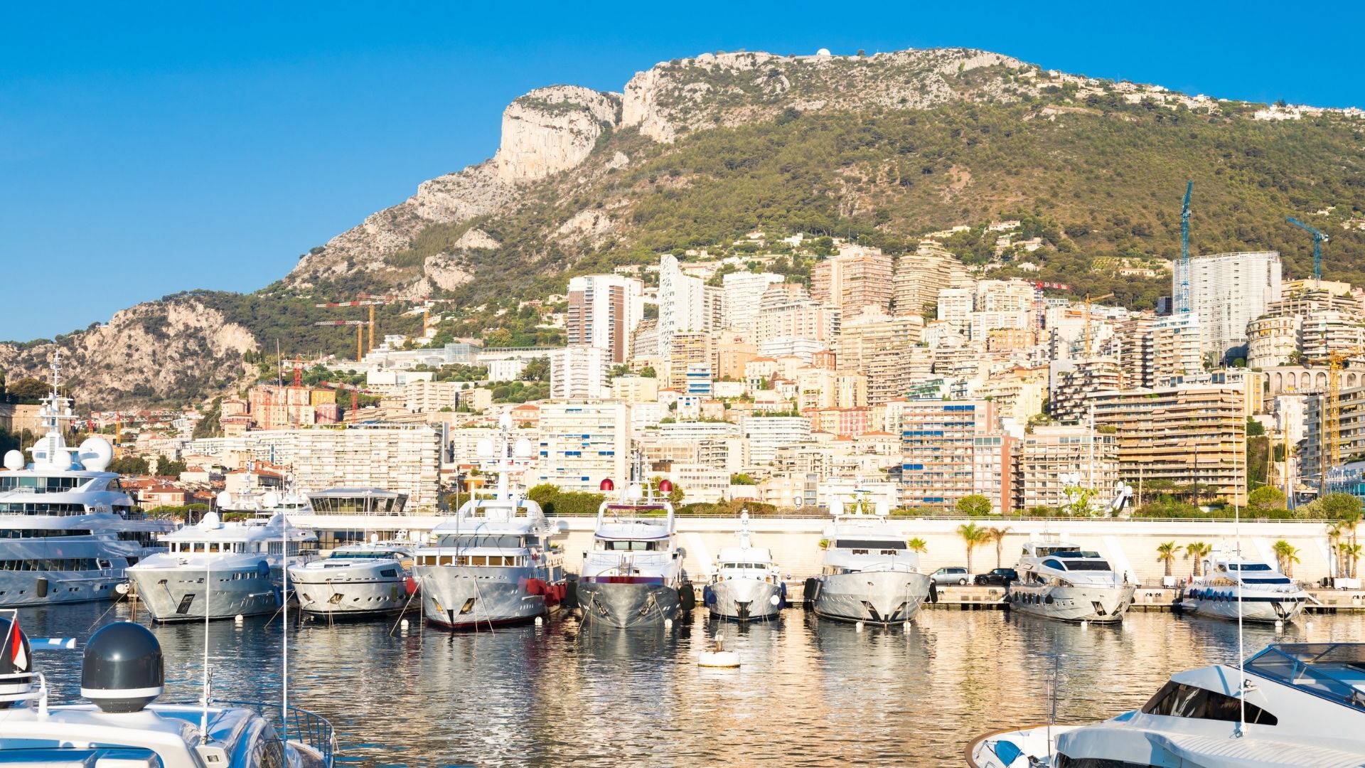 Monaco's Port Hercule with motor yachts stern-to on the quay.