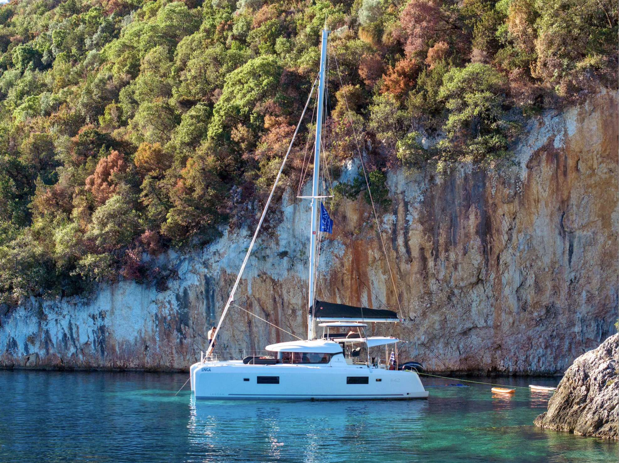 Yacht stern-to in a Cap Ferrat cove or off the Villefranche anchorage — the deep water inside Villefranche Bay drops to ninety meters fifty meters off the beach, so even large motor yachts anchor close in.
