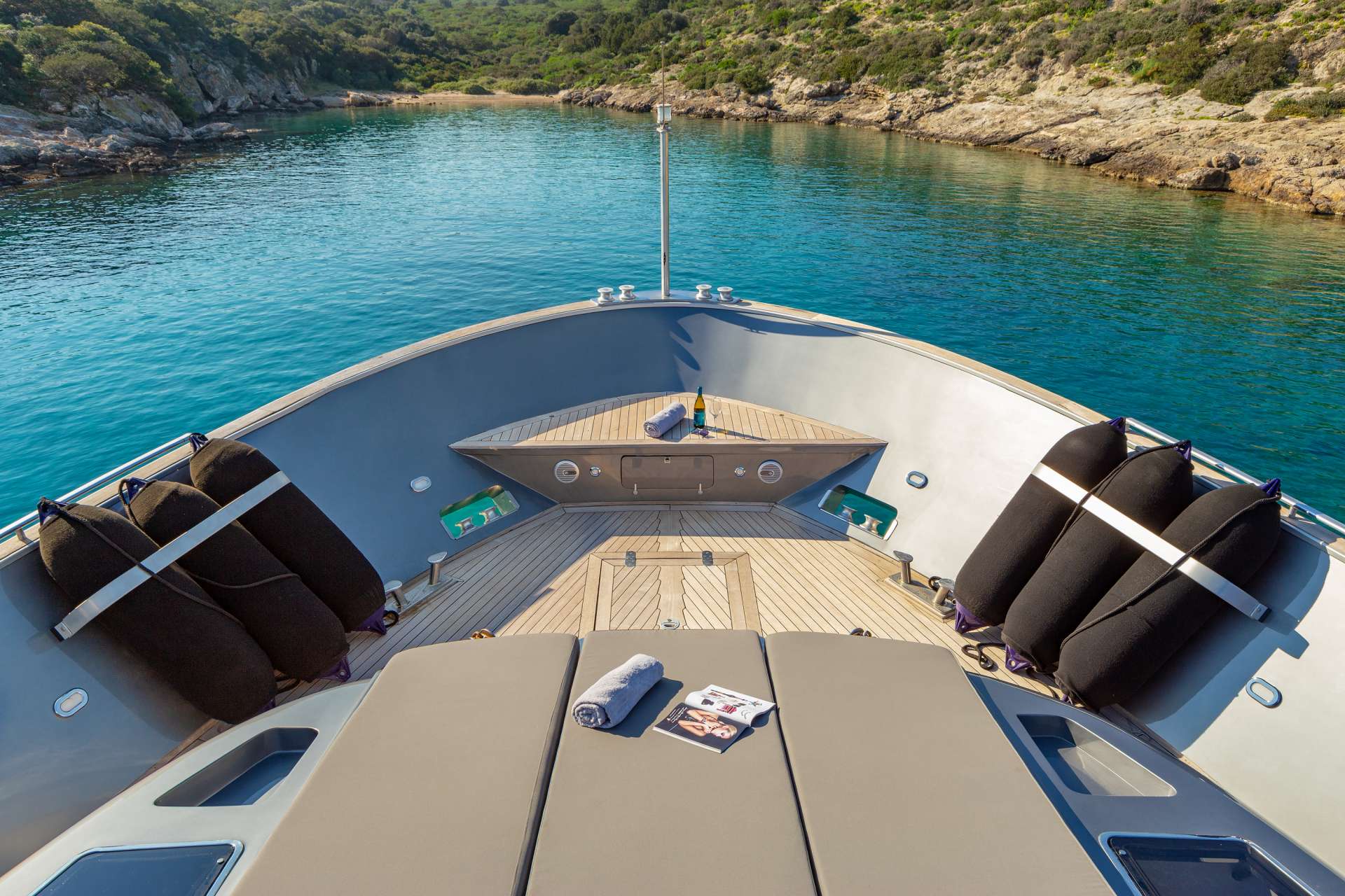 Foredeck lounge on the afternoon swim stop off Palmaria — paddleboards on the platform, the boat reading like the basecamp it is on this week. The slower close before the westbound return.