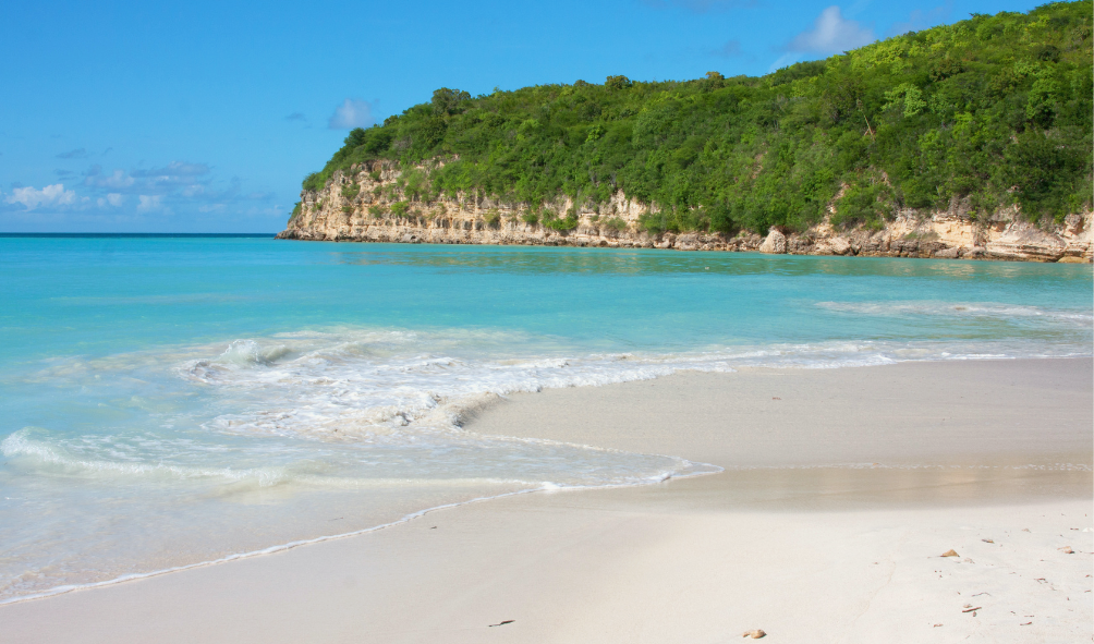 Explore Dickenson Bay in Antigua - a busy bay with great anchoring, water sports, and dining options. Enjoy the Kon Tiki floating bar and scenic views.