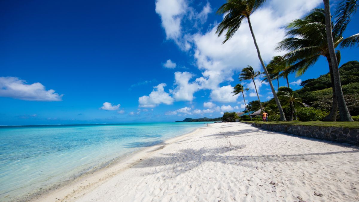 Matira Beach, Bora Bora, is renowned for its white sands and turquoise waters, offering idyllic swimming and sunbathing.