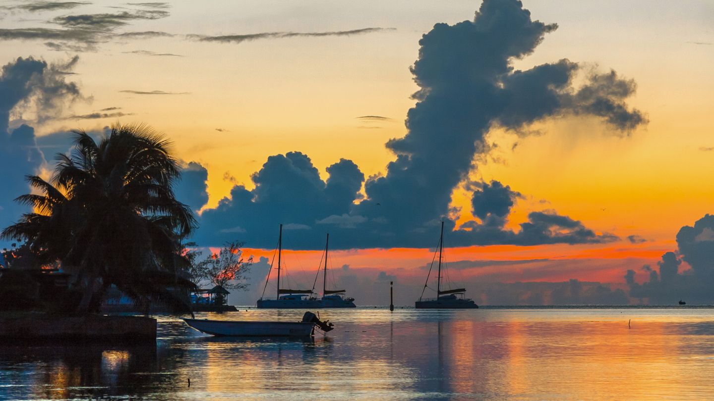 Relax at Avea Bay, Huahine, a serene beach with clear waters, ideal for swimming and sunbathing.