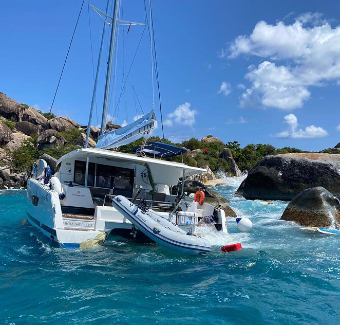 The yacht against rocks with red flag warning